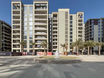 a fountain in a plaza in front of tall buildings at Frank Porter - Vida Creek Beach in Dubai