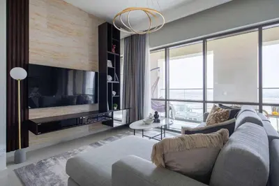 a living room with a couch and a tv at Frank Porter - Vida Creek Beach in Dubai