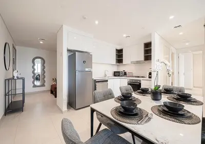 a kitchen and dining room with a table and chairs at Stylish Flat in Downtown Dubai with PS5 Gym and Pool in Dubai