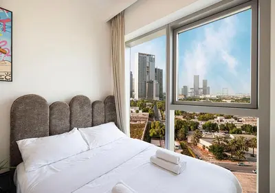 a bedroom with a white bed and a large window at Stylish Flat in Downtown Dubai with PS5 Gym and Pool in Dubai