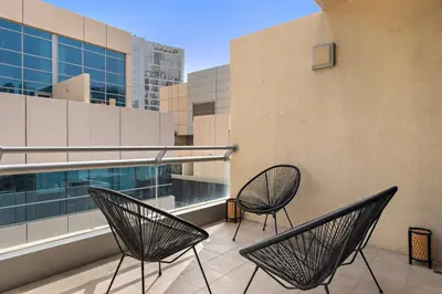two chairs sitting on the balcony of a building at 1BR with Study City View in Bay Square B13 in Dubai