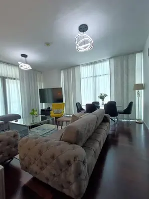 a living room with a couch and a table at Quill Residence - Canal View Spacious 3 bedroom Apartment in Dubai
