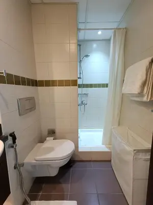 a bathroom with a toilet and a shower at Quill Residence - Canal View Spacious 3 bedroom Apartment in Dubai