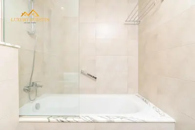 a bathroom with a bath tub with a shower at Elegant 2-BR with Canal & City Views Pool Amenities in Dubai