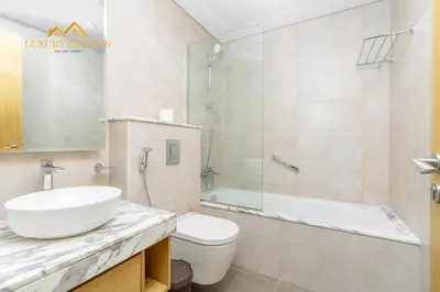 a bathroom with a sink and a toilet and a shower at Elegant 2-BR with Canal & City Views Pool Amenities in Dubai