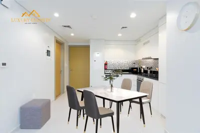 a kitchen and dining room with a table and chairs at Elegant 2-BR with Canal & City Views Pool Amenities in Dubai