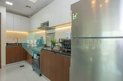 a large kitchen with a stainless steel refrigerator at Bloomfields Modern 1bedroom In Wavez in Dubai