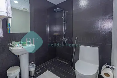a bathroom with a shower and a toilet and a sink at Bloomfields Modern 1bedroom In Wavez in Dubai