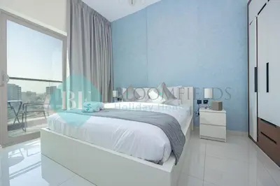 a bedroom with a white bed and a large window at Bloomfields Modern 1bedroom In Wavez in Dubai
