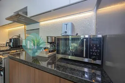 a kitchen with a microwave on a granite counter top at Bloomfields Modern 1bedroom In Wavez in Dubai