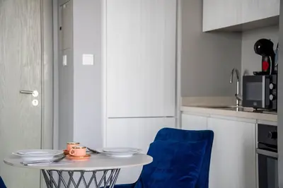a small kitchen with a table and a blue chair at Elegant Escapes - Lavish 1B,Dubai Water Canal View in Dubai