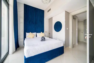 a bedroom with a large bed with blue walls at Elegant Escapes - Lavish 1B,Dubai Water Canal View in Dubai