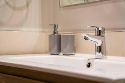 a bathroom sink with two cups on top of it at Elegant Escapes - Lavish 1B,Dubai Water Canal View in Dubai