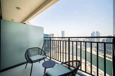 a balcony with two chairs and a view of the city at Elegant Escapes - Lavish 1B,Dubai Water Canal View in Dubai