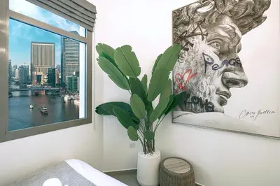 a bedroom with a picture of a face on the wall at A Marina Luxe Retreat in Dubai