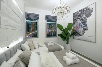 a living room with a white couch and a chandelier at A Marina Luxe Retreat in Dubai