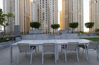 a table and chairs on a patio with tall buildings at A Marina Luxe Retreat in Dubai