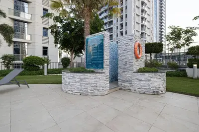 a statue in a park in front of a building at A Marina Luxe Retreat in Dubai