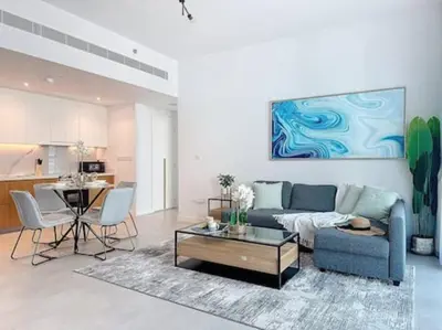 a living room with a blue couch and a table at La Vie JBR Gorgeous One Bedroom Beach Access Panoramic Pool in Dubai