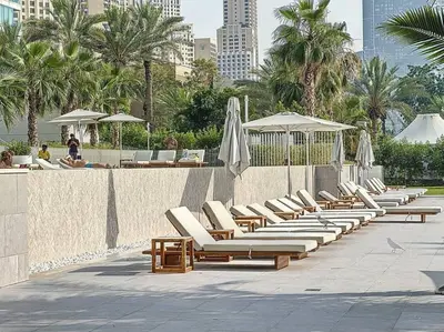 a row of lounge chairs and umbrellas at a resort at La Vie JBR Gorgeous One Bedroom Beach Access Panoramic Pool in Dubai