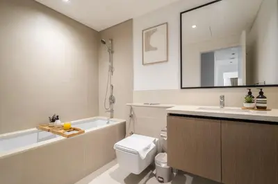 a bathroom with a tub and a toilet and a sink at Luxury High Floor Apartment with Downtown Boulevard View Opposite Dubai Mall in Dubai