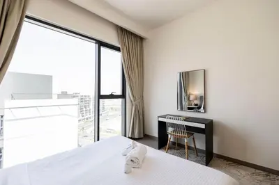 a bedroom with a bed and a desk and a window at Executive Residence-Dubai Hills by Serenity Living in Dubai
