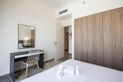 a bedroom with a bed and a desk and a mirror at Executive Residence-Dubai Hills by Serenity Living in Dubai
