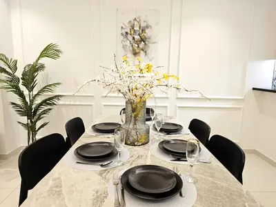 a dining room table with chairs and a vase of flowers at 5 Star High Rise Luxury Apartment, Infinity Pool With Stunning Burj View - Brand New Apartment in Dubai