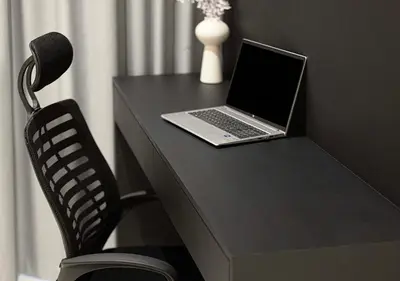 a laptop computer sitting on a desk with a chair at 5 Star High Rise Luxury Apartment, Infinity Pool With Stunning Burj View - Brand New Apartment in Dubai