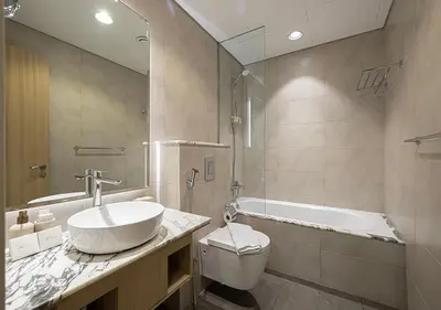 a bathroom with a sink and a tub and a toilet at 5 Star High Rise Luxury Apartment, Infinity Pool With Stunning Burj View - Brand New Apartment in Dubai