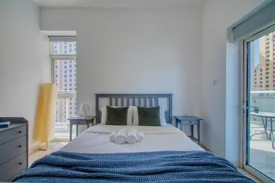 a bedroom with a bed with two towels on it at ShoresInn - Elegant 2BR with Dubai Marina View in Dubai