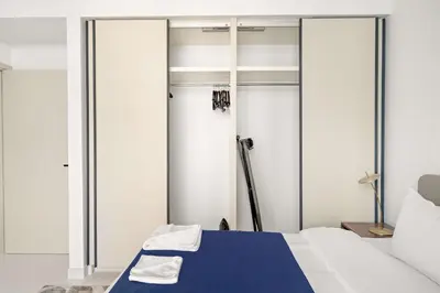 a bedroom with a blue bed and sliding glass doors at Silkhaus 1BDR in Marina Vista with Private Beach in Dubai