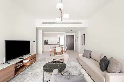 a living room with a couch and a tv at Silkhaus 1BDR in Marina Vista with Private Beach in Dubai