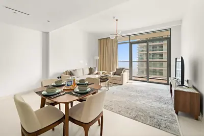 a living room with a table and chairs and a couch at Silkhaus 1BDR Marina Vista with Private Beach Access in Dubai