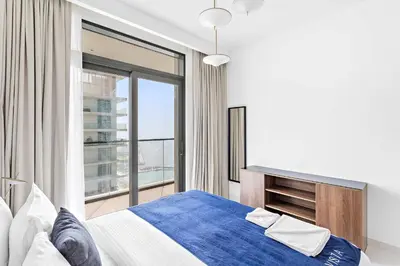a bedroom with a bed and a large window at Silkhaus 1BDR Sea View Retreat with Private Beach in Dubai