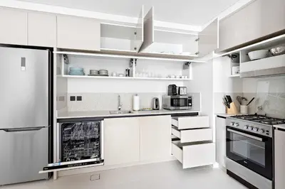 a white kitchen with white cabinets and appliances at Silkhaus 1BDR Sea View Retreat with Private Beach in Dubai