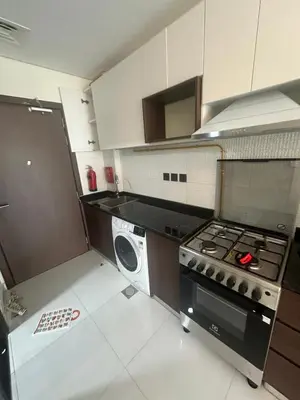 a kitchen with a stove and a washing machine at Peaceful Studio Getaway in Liwan in Dubai