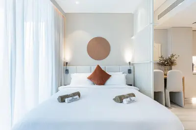 a hotel room with two beds and a table at Luxe Central Marina Studio with Rooftop Pool in Dubai
