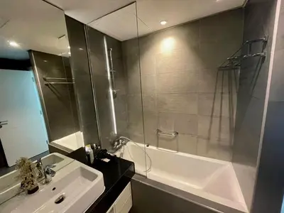 a bathroom with a shower and a tub and a sink at Damac canal views building in Dubai