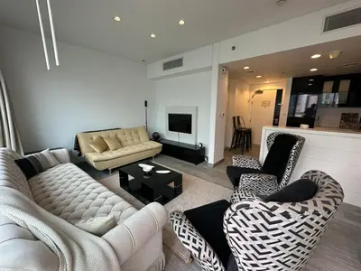 a living room with two couches and a tv at Damac canal views building in Dubai