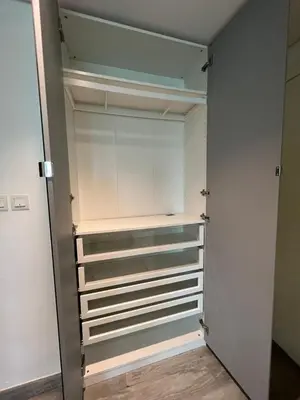 a walk in closet with white walls and shelves at Damac canal views building in Dubai