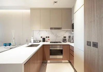 a kitchen with white counter tops and wooden cabinets at Luxurious 2BR at Address Opera with Boulevard Views in Dubai