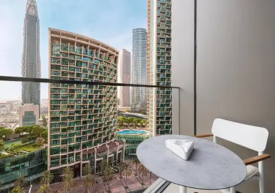 a balcony with a table and a view of a city at Luxurious 2BR at Address Opera with Boulevard Views in Dubai