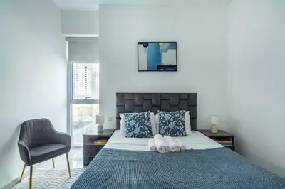 a bedroom with a bed and a chair at ShoresInn - Luxury 1BR with Marina View in Dubai