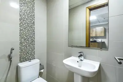 a bathroom with a sink and a toilet and a mirror at ShoresInn - Luxury 1BR with Marina View in Dubai