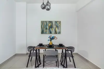 a dining room table with chairs and a painting on the wall at ShoresInn - Luxury 1BR with Marina View in Dubai