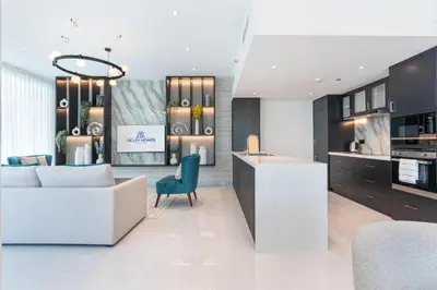a kitchen and living room with a couch and a table at Elegant & Cozy 2BR Home in the Heart of Downtown in Dubai