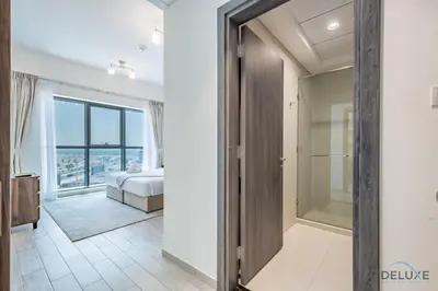 a bedroom with a bed and a walk in shower at Stylish 1BR Apartment at Orchid Residence, Al Barsha South by Deluxe Holiday Homes in Dubai