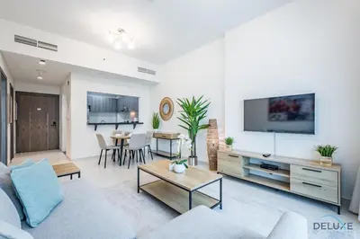 a living room with a couch and a tv at Stylish 1BR Apartment at Orchid Residence, Al Barsha South by Deluxe Holiday Homes in Dubai