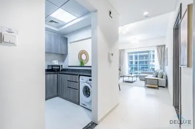 a kitchen and living room with a washer and dryer at Stylish 1BR Apartment at Orchid Residence, Al Barsha South by Deluxe Holiday Homes in Dubai